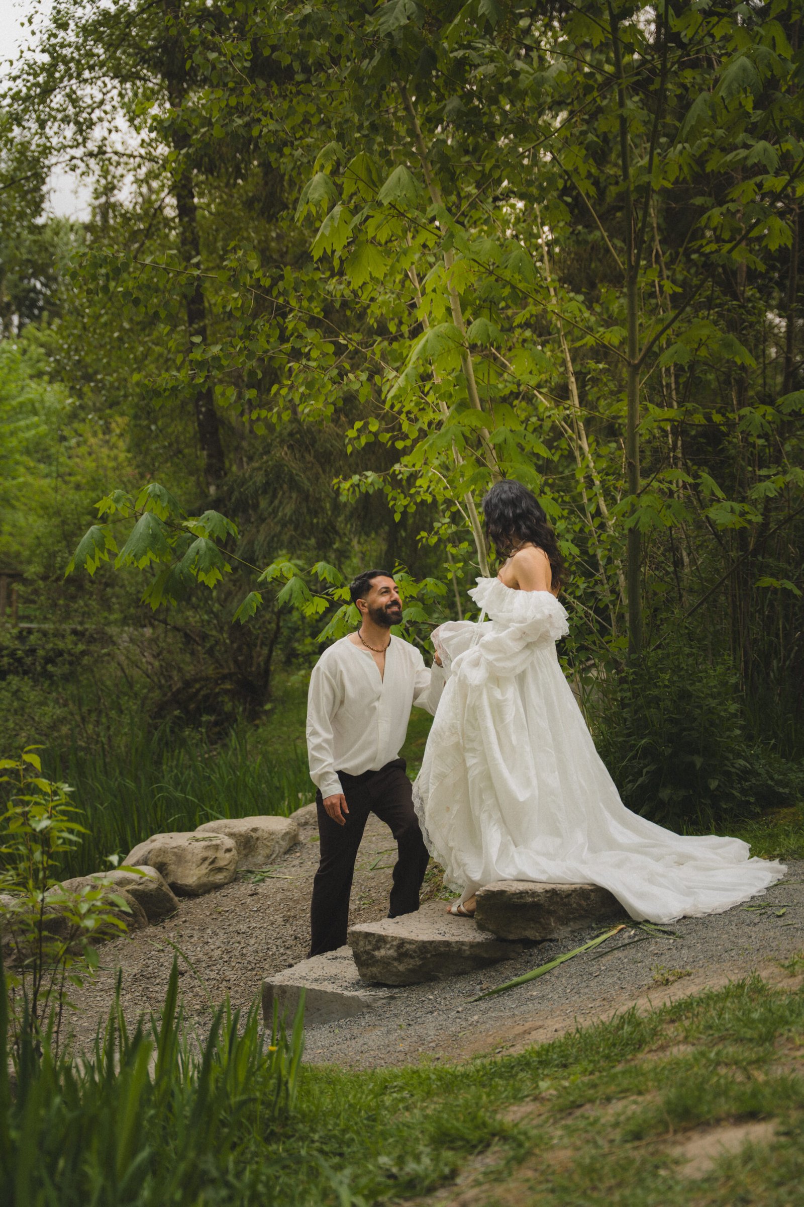 Bride and groom on a stone bridge in a lush forest